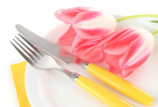 Сервировка праздничного обеденного стола с тюльпанами, изолированными на белом