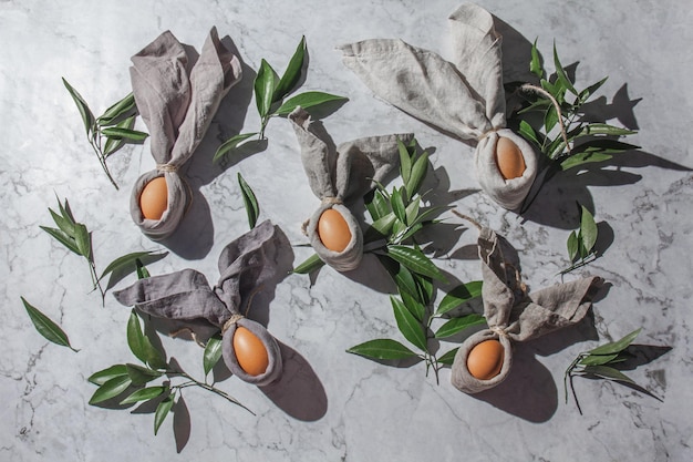 Sfondo pasquale festivo con uova di coniglietto pasquale su tovagliolo di lino decorazione pasquale vista dall'alto copia spazio