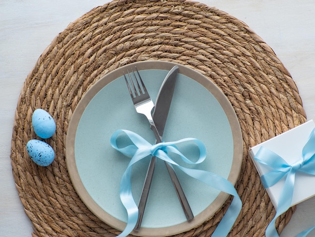 Festive Easter table setting with eggs and gift box on brown background