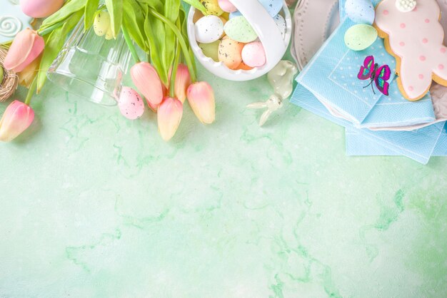 伝統的な春の花、イースターのカラフルな卵とシュガークッキーでお祝いイースターテーブルの設定