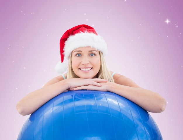 Festive fit blonde leaning on exercise ball