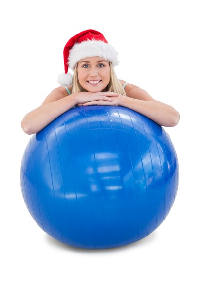 Festive fit blonde leaning on exercise ball