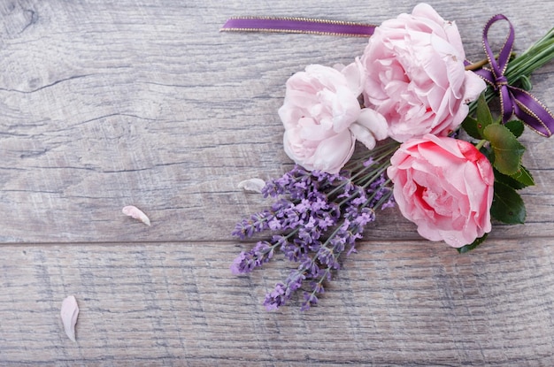 Foto composizione di rose di fiori festosi con lavanda a nastro su fondo in legno in stile rustico vista dall'alto dall'alto piatto laico copia spazio compleanno madri san valentino womens concetto di giorno di nozze