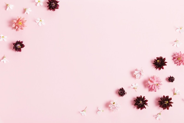 Photo festive flowers composition frame made of pink and purple small flowers on pink background