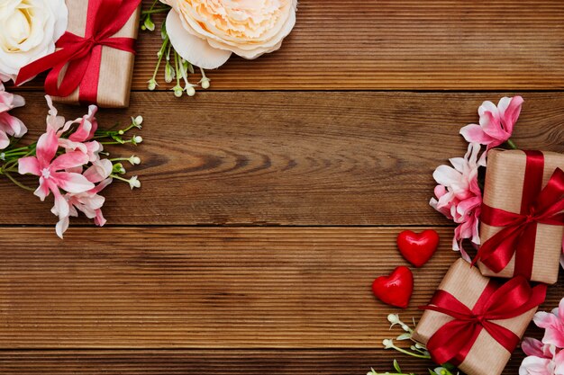 Festive gift boxes and bouquet of flowers on wooden background with copy space. Valentine's day, love.