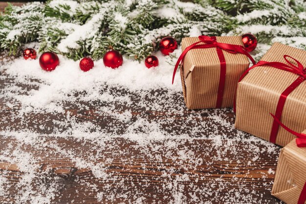 Festive gift with bow close up on wooden  with snow