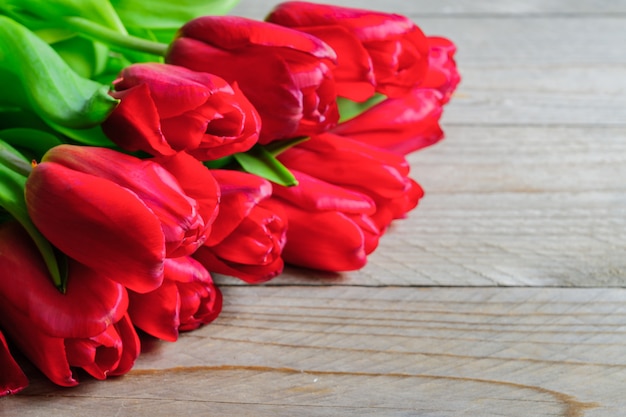 Festive greeting card with bouquet of blooming red tulips.