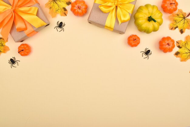 Festive Halloween background with gifts, pumpkins and spiders . Top view. Banner from the decor for the Halloween holiday.