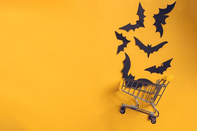 Festive halloween background with paper bats on a shopping trolleymock up flatly for party or sale top viewcopy space