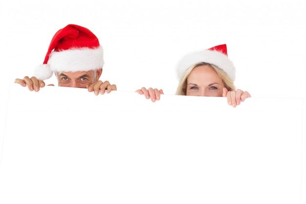 Festive happy couple holding large poster