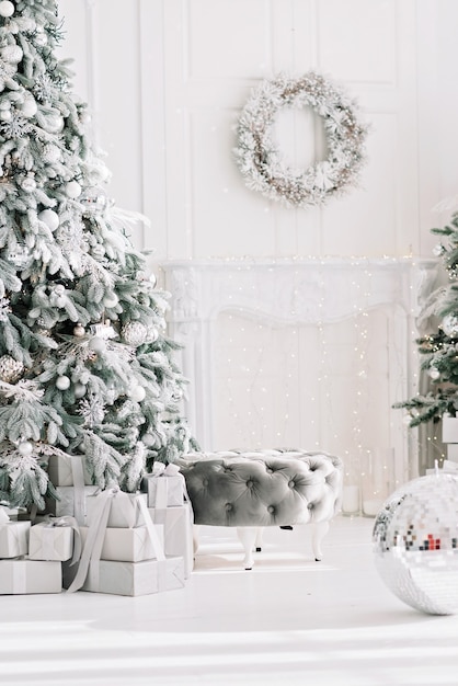 Festive interior. Luxurious Christmas tree decorated with lights with gifts