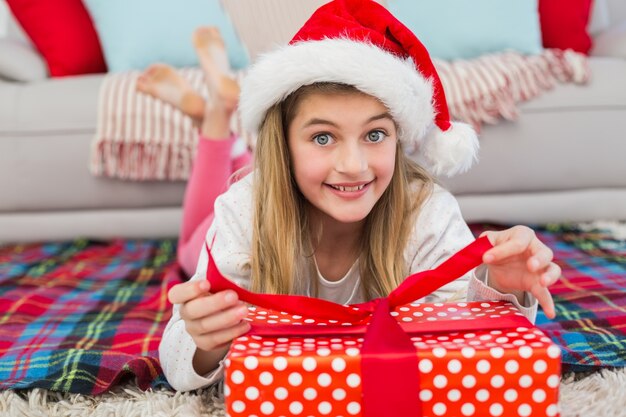 Festive little girl opening a gift