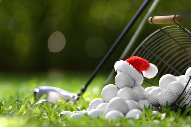 Festive-looking golf ball on tee with Santa Claus' hat on top for holiday season on golf course background

