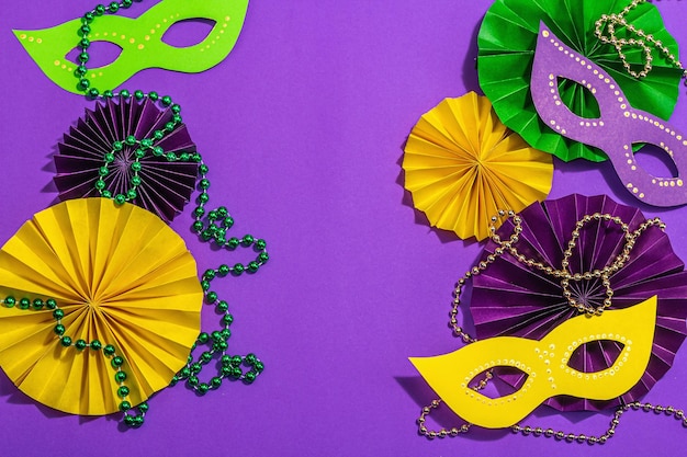 Festive Mardi Gras masquerade purple background Fat Tuesday carnival masks beads traditional decor