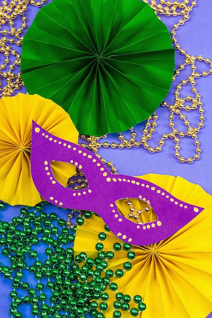 Foto festive mardi gras masquerade sfondo viola martedì grasso maschere di carnevale perline arredamento tradizionale colori simbolici trendy hard light dark shadow flat lay vista dall'alto