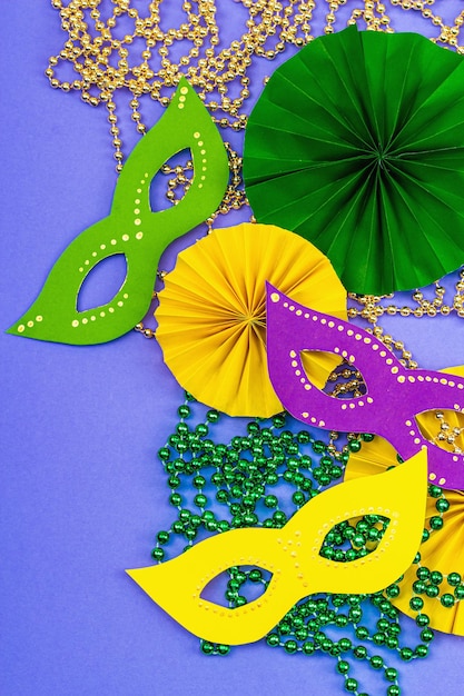 Праздничный Марди Гра маскарад фиолетовый фон Жирный вторник карнавальные маски бусы традиционный декор Символические цвета модные жесткие светлые темные тени плоский вид сверху