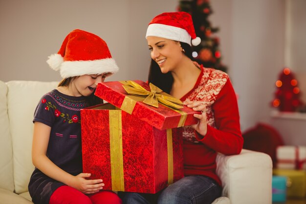 Photo festive mother and daughter opening a gift