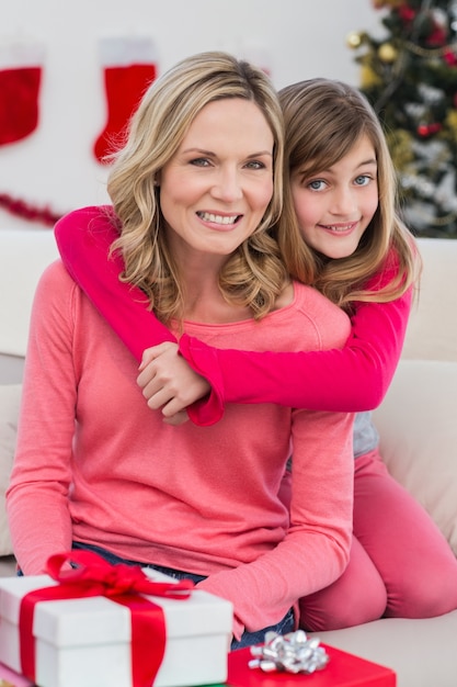 Festive mother and daughter smiling at camera