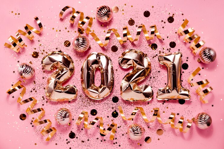 Photo festive new year flatlay background pink gold foil balloons and chrtistmas decorations. top horizontal view copyspace.
