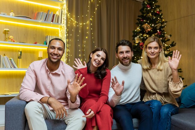 Festive online meeting a group of young interracial people are sitting on a sofa in an apartment