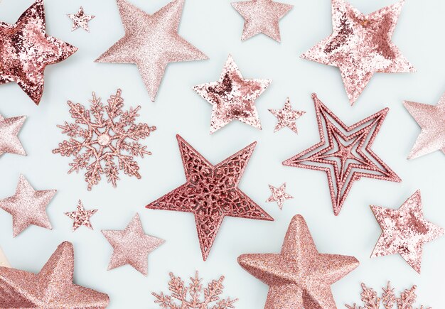 お祝いのパステルカラーの背景。クリスマスの星と輝くキラキラ、パステルカラーの背景に紙吹雪。クリスマスの背景、フラットレイ。