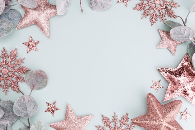 Festive pastel background. Christmas stars and shining glitter, confetti on pastel background. Christmas background, Flat lay.