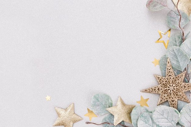 Festive pastel background. Christmas stars and shining glitter, confetti on pastel background. Christmas background, Flat lay.