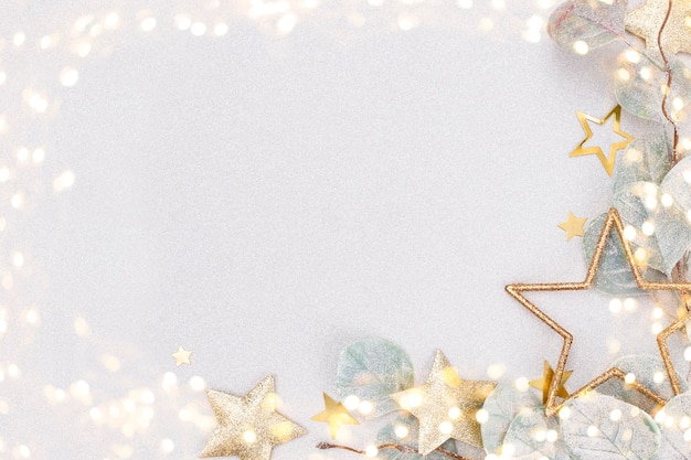 Festive pastel background. Christmas stars and shining glitter, confetti on pastel background. Christmas background, Flat lay.