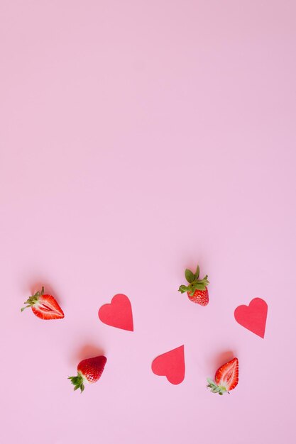 Festive pink background. Red paper hearts, fresh strawberries. Love. Valentine's Day. 14 of February