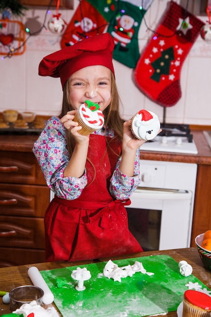 Festive red apron Christmas party dinner dessert peppermint cupcakes cheese cream sugar sprinkling decoration