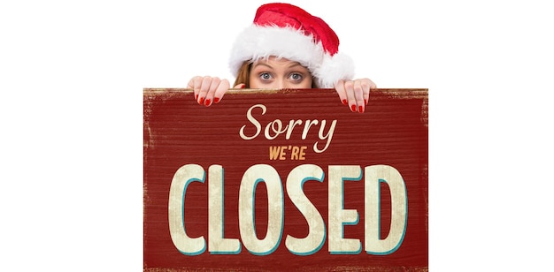 Photo festive redhead smiling at camera holding poster against vintage closed sign