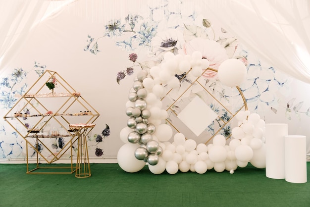 Festive round photo zone with white and silver balls for an event or birthday and a buffet in the tent