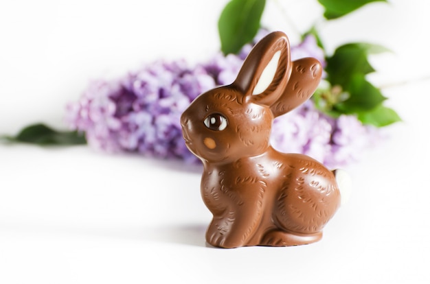 Festive still life with Chocolate Easter Bunny and lilac flowers.