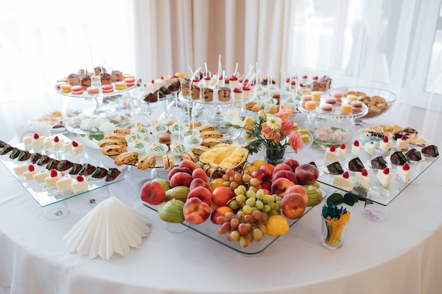 Foto tavolo festivo fatto di frutta e dolci