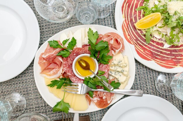 Festive table setting family dinner with served italian antipasti - marinated salmon hamon