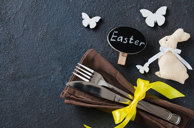 Festive table setting for holiday Easter dinner on dark table.