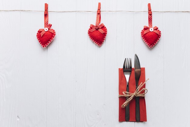 Photo festive table setting for valentine's day with fork, knife and hearts