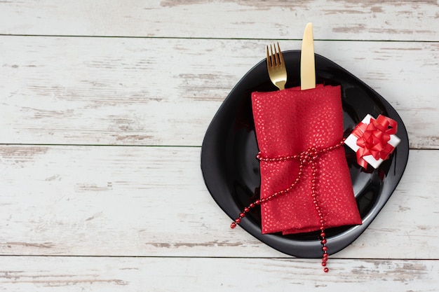 Festive table setting for Valentine's Day with golden fork and knife and decorations.