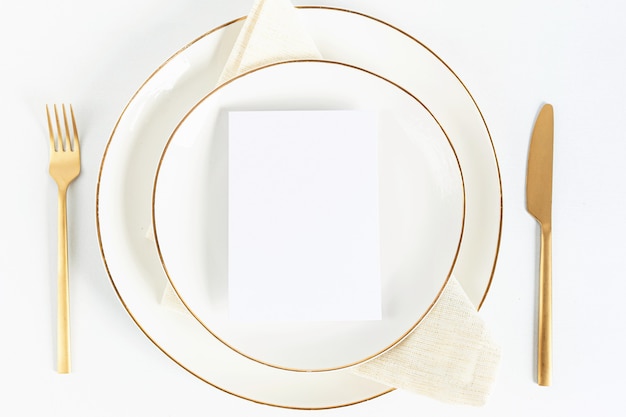 Photo festive table setting with golden cutlery and porcelain plate