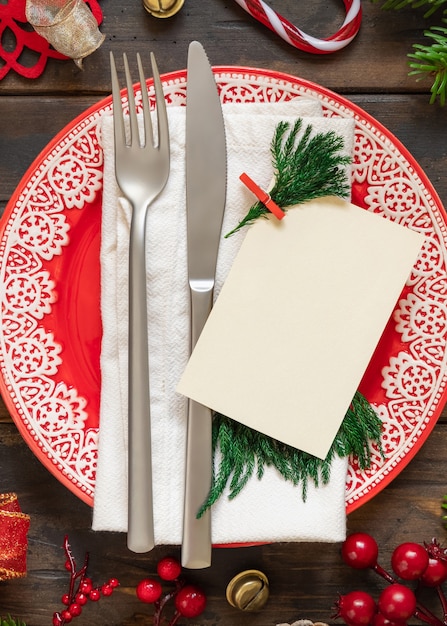 Festive table setting with ornaments fir tree branches and blank card top view Mockup