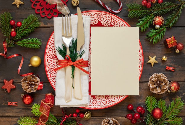 Festive table setting with ornaments fir tree branches and blank card top view