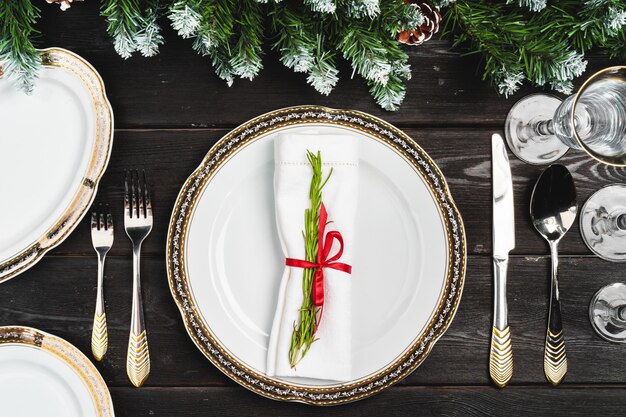 Festive table setting with pine tree branches on wooden 