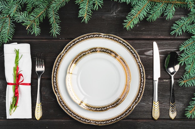 Festive table setting with pine tree branches on wooden 