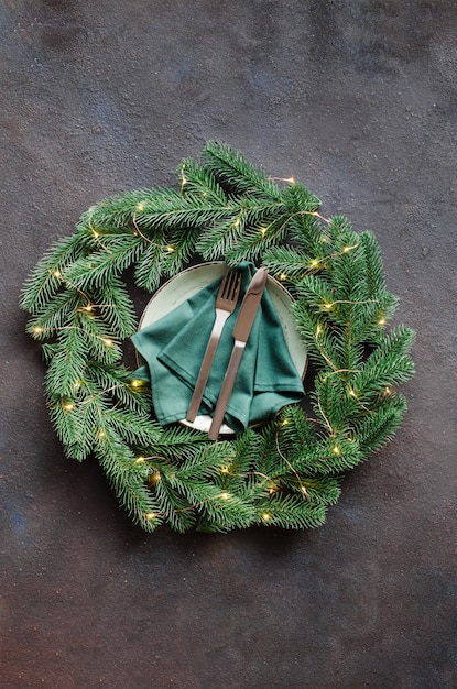 Festive table setting with xmas decorations in the form of a Christmas wreath.