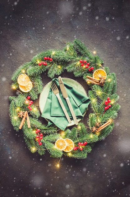 Festive table setting with xmas decorations in the form of a Christmas wreath