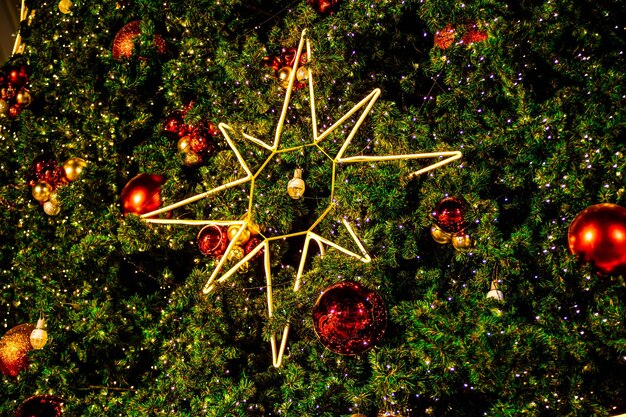 Foto albero di natale all'aperto decorato in modo festivo con palle rosse brillanti