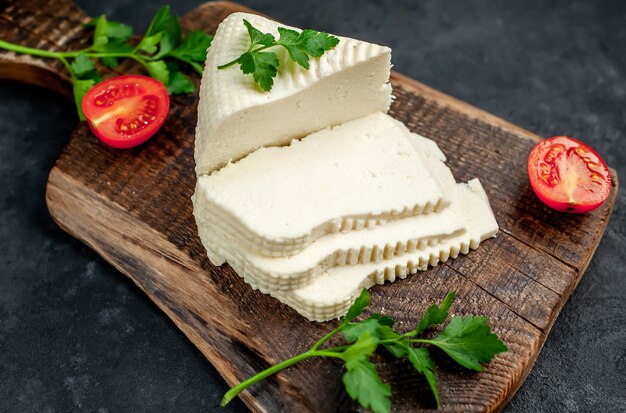 Feta cheese with cherry tomatoes on a cutting board