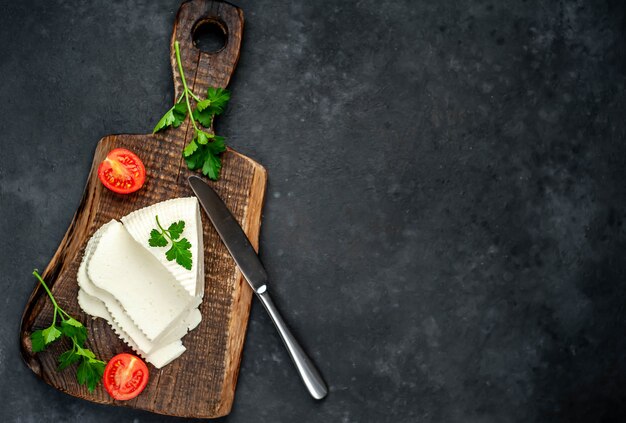 Feta cheese with cherry tomatoes on a cutting board