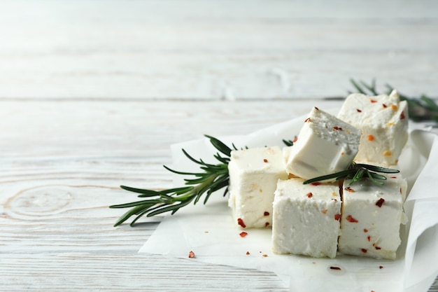 Feta cheese with spices and rosemary on white wooden