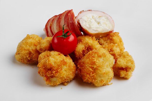 Feta cheese wrapped by bacon and fried in oil with potato in breading